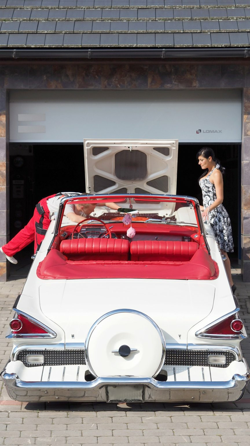  Rot-weißer Veteran vor einer offenen Garage